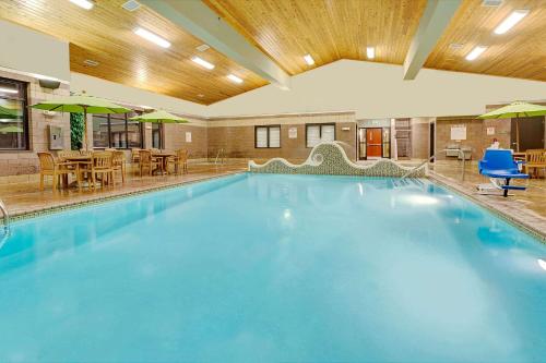 - une grande piscine dans un hôtel avec des tables et des chaises dans l'établissement Days Inn by Wyndham Cheyenne, à Cheyenne