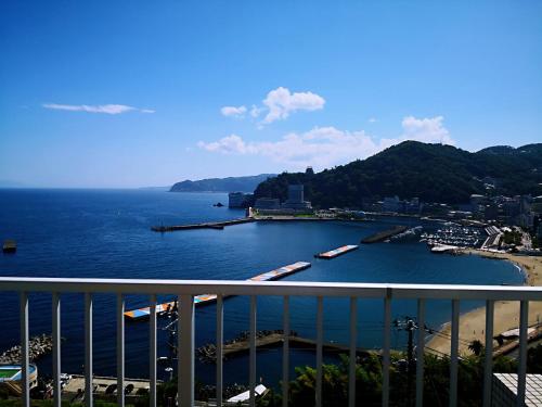 een uitzicht op een waterlichaam met boten erin bij Atami Onsen Guest House Megumi in Atami