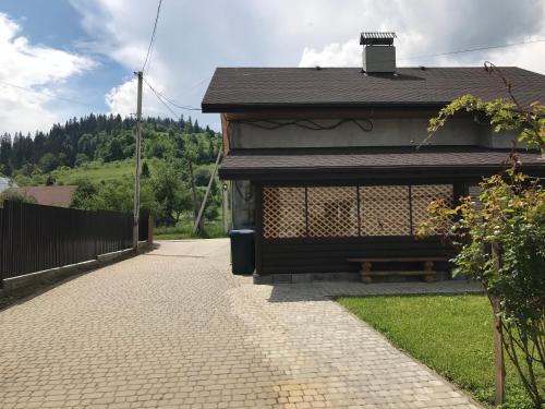 un edificio con un banco junto a una acera en Артемів двір, en Slavske