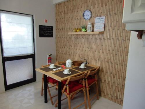 uma mesa com cadeiras e um relógio na parede em Casa do Algarve em Albufeira