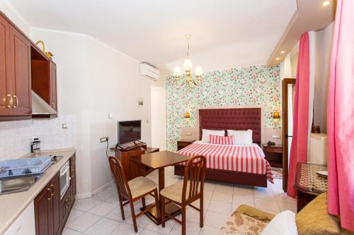 een keuken en een slaapkamer met een bed en een tafel bij Olympic Apartments in Parga