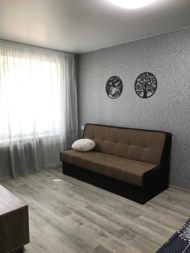 salon z brązową kanapą w pokoju w obiekcie Apartments O.Polya ( Kirova) 106 w mieście Dniepr