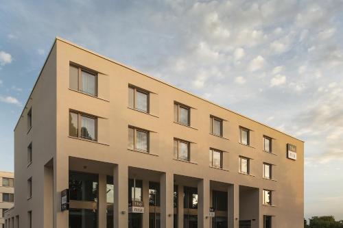 un edificio abbronzato con finestre sul lato di Holiday Inn - the niu, Hop Forchheim, an IHG Hotel a Forchheim