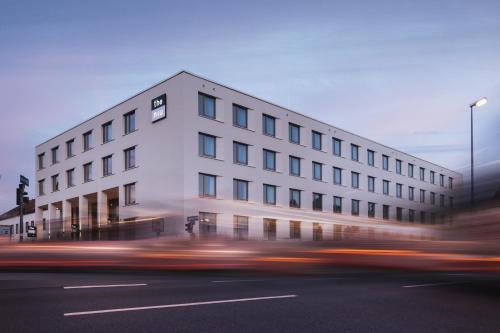 un edificio bianco sul lato di una strada di Holiday Inn - the niu, Hop Forchheim, an IHG Hotel a Forchheim