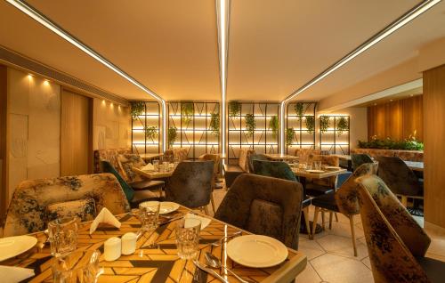 un restaurante con mesas y sillas en una habitación en Sapphire Boutique Hotel, en Thane