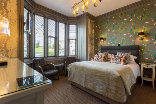 a bedroom with a bed and a wall of windows at Jerichos Boutique Accommodation in Windermere