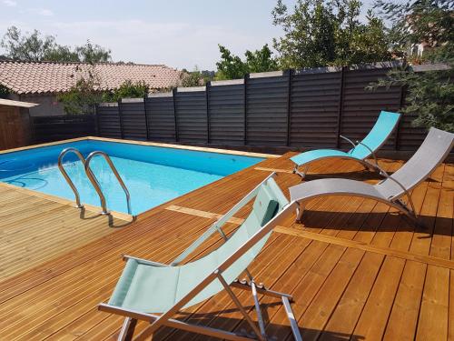 a deck with two chairs and a swimming pool at Chambre d hôtes de la Louve in Fréjus