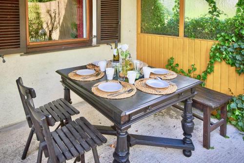 een houten tafel met stoelen en borden erop bij Payerbach Apartments in Payerbach