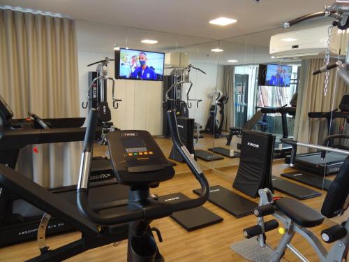 - une salle de sport avec des tapis de course et une télévision en arrière-plan dans l'établissement Marante Executive Hotel, à Récife