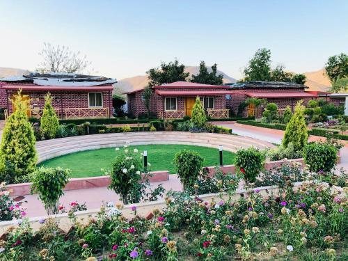 a garden with flowers in front of a building at DESI THATH RESORT in Alwar