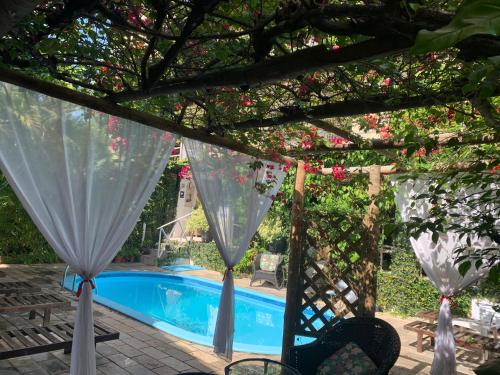 a view of a pool from under a pergola at Pousada Beijos y Abraços in Natal