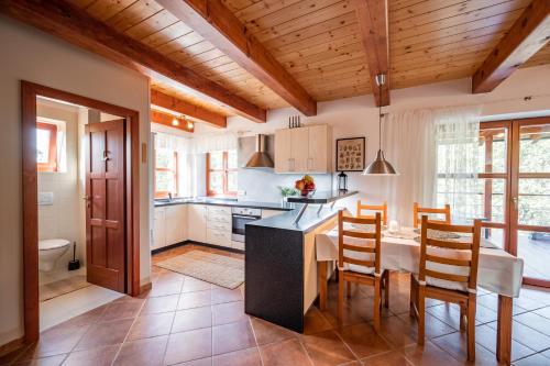 - une cuisine et une salle à manger avec une table et des chaises dans l'établissement Chata nad lázeňským údolím, à Luhačovice