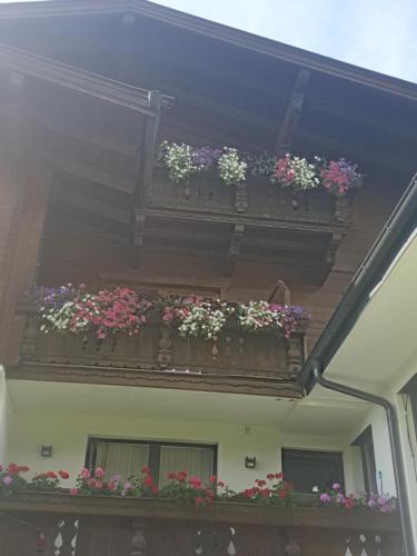 einen Balkon mit Blumenkästen an der Seite eines Gebäudes in der Unterkunft Appartementhaus Hüttenberger in Erpfendorf