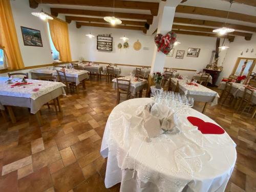 een eetkamer met tafels met witte tafelkleden bij Al Castello in Artegna