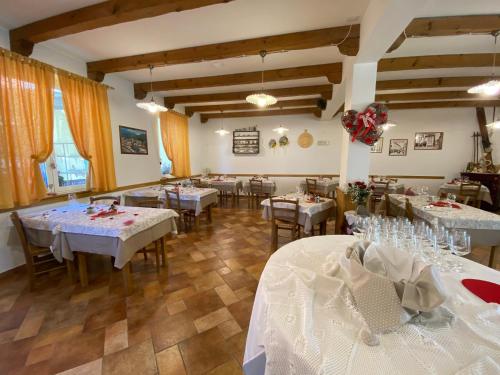 een restaurant met tafels en stoelen met witte tafelkleden bij Al Castello in Artegna