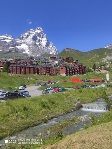 un hotel en una colina con una montaña en el fondo en TANA DELLA MARMOTTA - renovated, ski in ski out, turkish bath, garage, storage, en Breuil-Cervinia