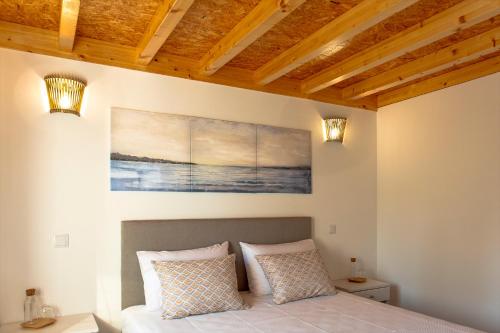 a bedroom with a bed and a painting on the wall at Casa Marmelos - Alojamento Local in Ourém