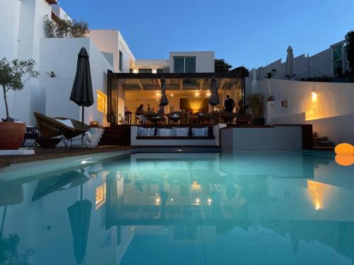 a swimming pool with a restaurant in the background at Casas Do Moinho - Turismo De Aldeia in Odeceixe