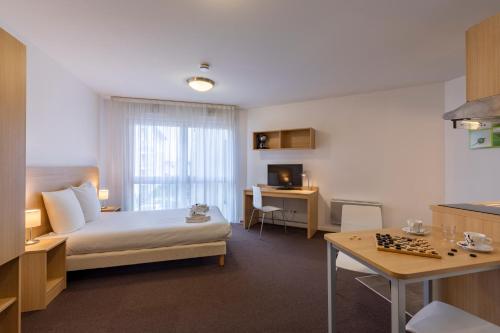 una camera d'albergo con letto e scacchiera di The Originals Residence, Kosy Appart'hotels Troyes City & Park a Troyes