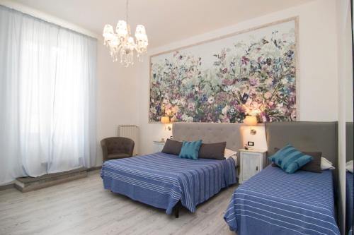 um quarto com duas camas e um quadro na parede em B&B 7 Rooms em Pisa