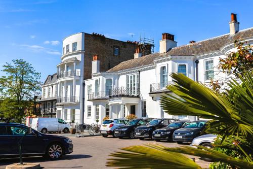 eine Reihe von Autos, die vor den Gebäuden geparkt sind in der Unterkunft Harbour Hotel & Spa Richmond in Richmond upon Thames