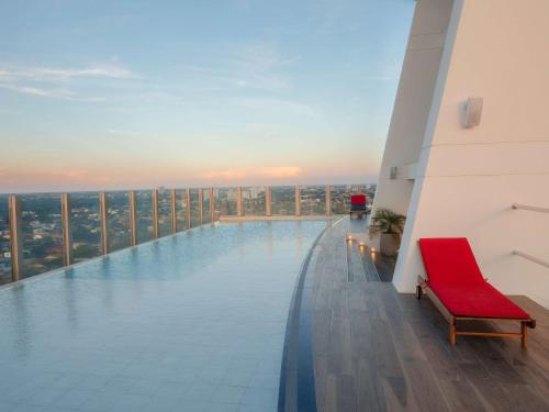 una piscina in cima a un edificio con sedia rossa di Swissotel Santa Cruz de La Sierra a Santa Cruz de la Sierra