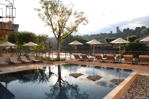 een zwembad in een hotel met stoelen en parasols bij Corte Regia Relais & Spa in Valeggio sul Mincio