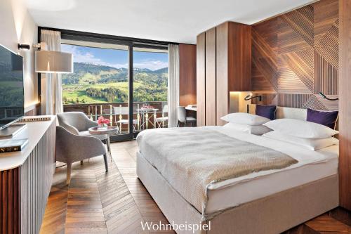 um quarto de hotel com uma cama grande e uma varanda em Allgäu Sonne em Oberstaufen