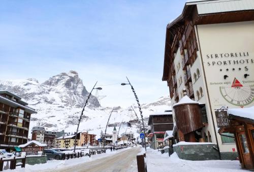 a snow covered street with a mountain in the background at Sertorelli Sporthotel in Breuil-Cervinia