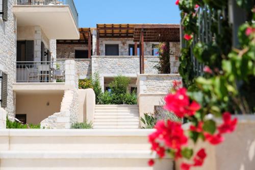 a view of a building with stairs and red flowers at Margo Beach Hotel in Gythio