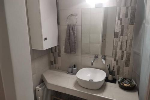 bagno con lavandino bianco e specchio di Luxury Townhouse a Larisa