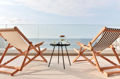 2 sillas de madera y una mesa frente a una ventana en ECO-APARTMENTS LA MARINEDA, en Roses