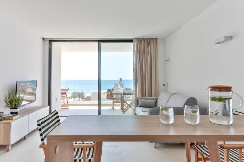 Sala de estar con mesa y vistas al océano en ECO-APARTMENTS LA MARINEDA, en Roses