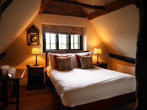 a bedroom with a large white bed with two lamps at Bear and Ragged Staff in Oxford