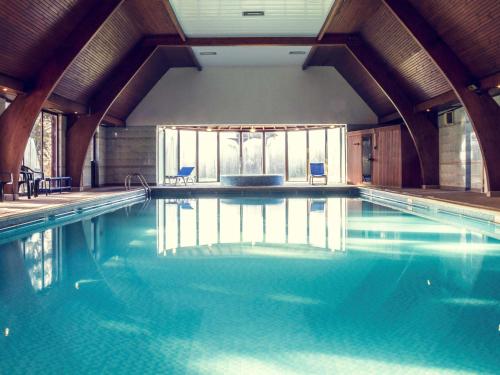 - une piscine d'eau bleue dans un bâtiment dans l'établissement Mercure Hull Grange Park Hotel, à Hull