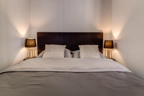 a bedroom with a large bed with two lamps at Hotel Maxim in Frýdek-Místek