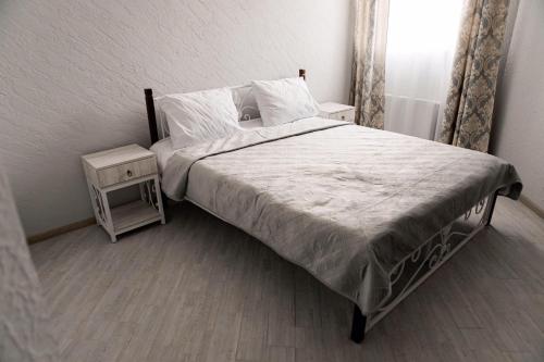 a bedroom with a large bed with a nightstand and a bed sidx sidx sidx at Отель-ресторан “Le Grand” in Zhytomyr