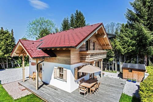 ツェル・アム・ゼーにあるChalet Dacha mit finnischer Saunaのデッキと赤い屋根付きのログホーム