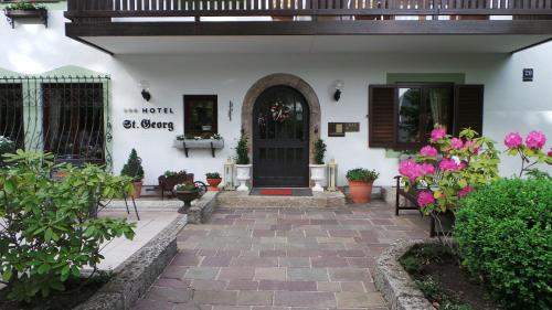 un porche delantero de una casa con una puerta negra en Hotel St. Georg, en Bad Reichenhall