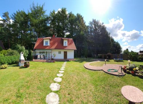 ein kleines Haus mit rotem Dach im Hof in der Unterkunft Domek na Kaszubach in Bieszkowice