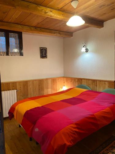 a bedroom with a colorful bed with two chairs at Frazione Duc Apartments in Sestriere