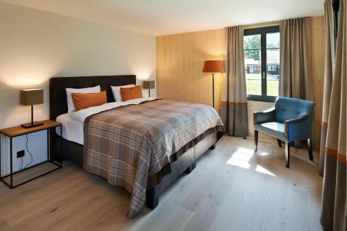 una camera d'albergo con letto e sedia blu di Eiger View Alpine Lodge a Grindelwald