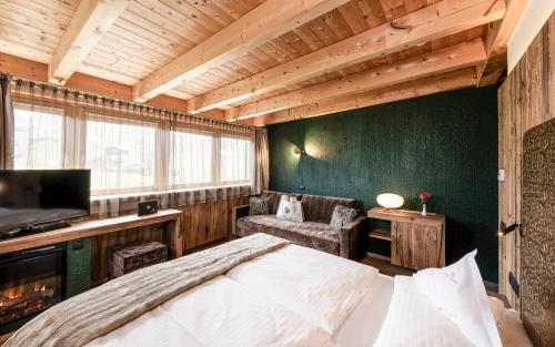 阿尔卑斯休斯山Hotel Santner Alpine Sport & Relax的一间卧室设有一张大床和绿色的墙壁