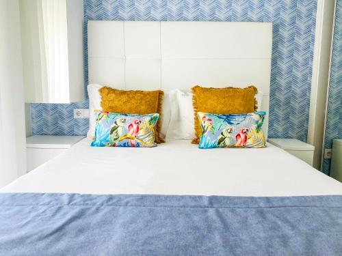 a large white bed with two pillows on it at Batata - Estúdios in Nazaré