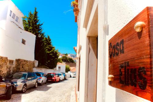 une rue avec des voitures garées sur le côté d'un bâtiment dans l'établissement Casa Elias, à Óbidos