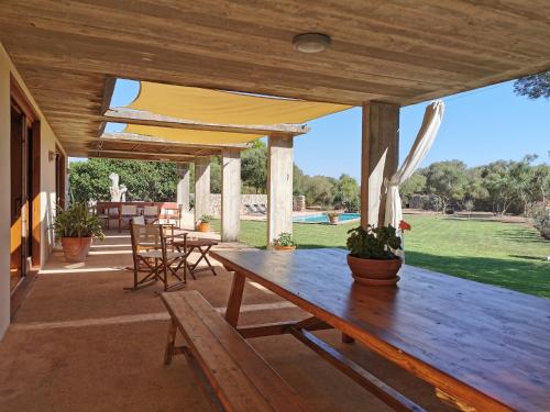 een houten patio met een houten tafel en stoelen bij Cucurutxa in Mahón