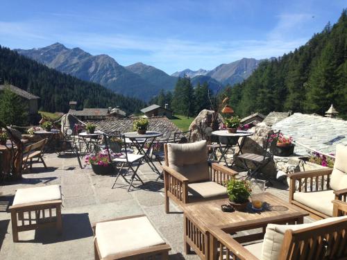 un patio con mesas y sillas y vistas a las montañas en Baita La Jolie Bergere, en La Salle