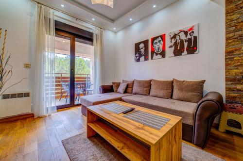 a living room with a couch and a coffee table at Vila Pekovic, Pine Trees View Apartment with big balcony in The Center of Zlatibor! in Zlatibor