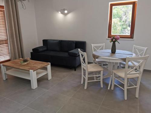 sala de estar con sofá, mesa y sillas en Apartman Kneže, en Korčula