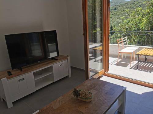 sala de estar con TV de pantalla plana y mesa en Apartman Kneže, en Korčula